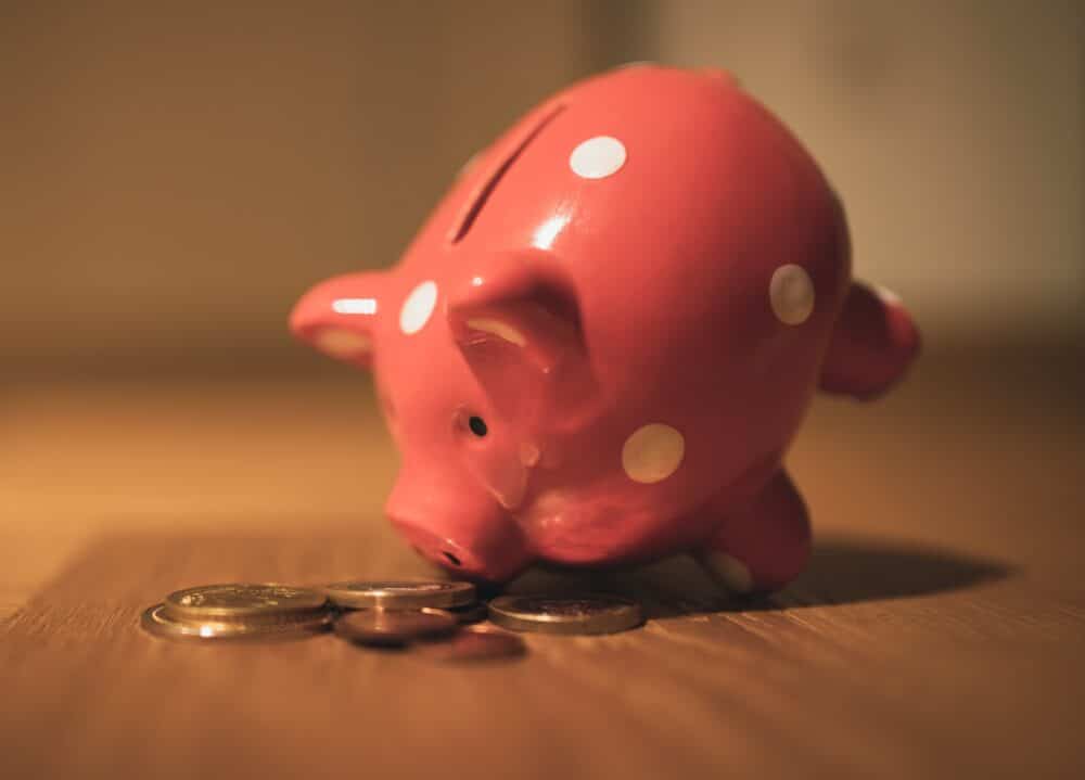 Piggy bank on table with some coins on the table