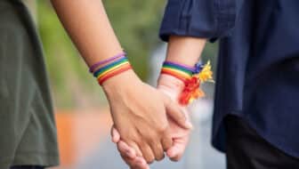 hand of LGBT women holding together with rainbow ribbon symbol; concept of LGBT pride, LGBTQ people, lgbt rights campaign, same gender marriage