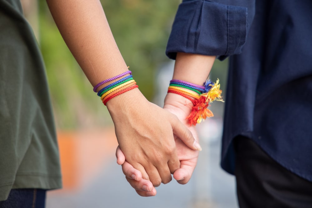 hand of LGBT women holding together with rainbow ribbon symbol; concept of LGBT pride, LGBTQ people, lgbt rights campaign, same gender marriage