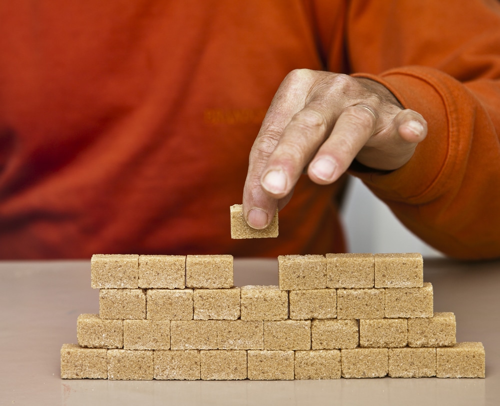 Man putting final block in a collection of blocks